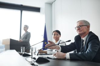 Painelistas participam de uma conferência sobre legislação e diplomacia em um auditório.